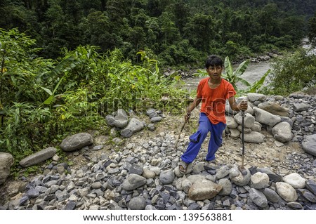BHALUKPONG, INDIA - SEPTEMBER 14: an itinerant labourer uses large hammer to break rocks for road construction on September 14, 2011 near Bhalukpong, western Arunachal Pradesh, India.