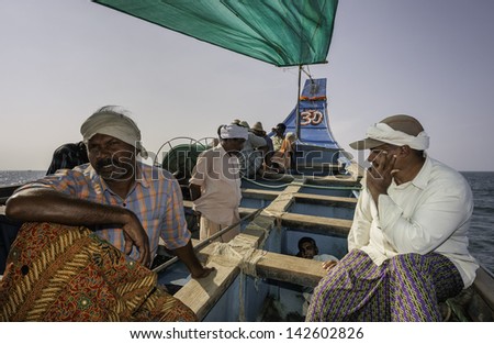 KANNUR, INDIA - DECEMBER 20: Fishermen in a traditional wooden boat set out on a deep sea fishing trip on December 20, 2011 from Mapilla Bay harbour, Kannur, Kerala, India.
