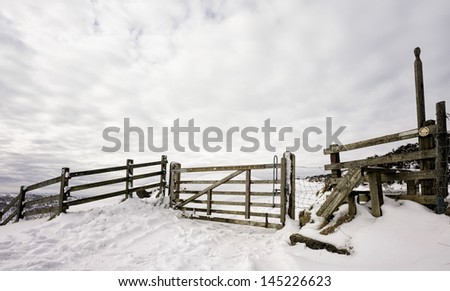 Goathland, Yorkshire, UK. A wooden sty, farm gate, as entrance to  the Hole of Horcum in the North York Moors National Park following a snow storm, Goathland, Yorkshire, UK.