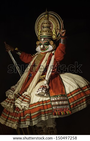 KANNUR, INDIA - DECEMBER 07: A Kathakali performer in full costume, head gear, and face make-up dances at the Parassinikadavu Muthappan Temple on December 07 2112 near Kannur, Kerala, India.