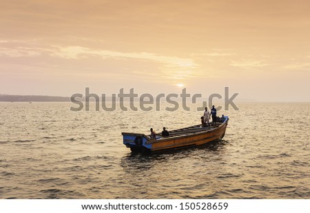 KANNUR, INDIA - DECEMBER 22:: Fishermen in a traditional wooden boat set out to sea on a fishing trip at sunrise off the Malabar Coast on December 22, 2012 near Thottada, Kannur, Kerala, India.