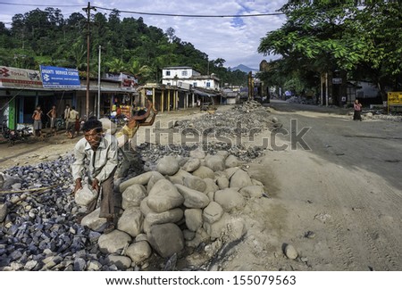 BHALUKPONG, INDIA - SEPTEMBER 14: Men work as breaking stones for road construction at border town of Bhalukpong on September 14, 2011 between Assam and Arunachal Pradesh, India.