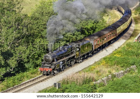 GOATHLAND, UK - SEPTEMBER 23: Vintage steam train makes its way through the North York Moors on a bright sunny morning in autumn on September 23, 2011 near Goathland, Yorkshire, UK.