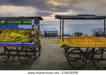 Pondicherry, south India. Overnight covers on mobile stalls along sandy beach and promenade at dawn, Pondicherry, South India. The sea is the Indian Ocean.