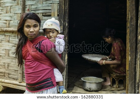TAWANG, INDIA - SEPTEMBER 19: Young itinerant labour family living in bamboo shack alongside the main road and construction workers on September 19, 2011 near Tawang, Arunachal Pradesh, India.