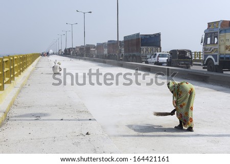 PATNA, INDIA - OCTOBER 14, 2011: Woman with hand broom sweeps bridge during renovation on October 14, 2011 at Patna, Bihar, India.