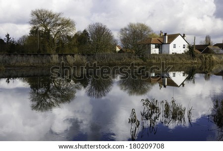 Beverley, Yorkshire, UK. River Hull on a bright winter's day showing the riverbank and houses with reflections in the water near Beverley, Yorkshire, UK.
