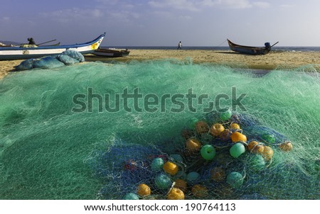 MAMALLAPURAM, INDIA - NOVEMBER 19: A large fishing net as a fisherman walks across the sandy beach on November 19, 2011 at Mamallapuram, Tamil Nadu, India.