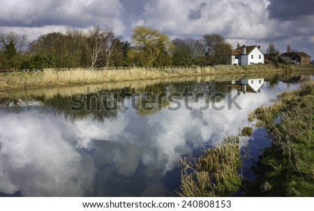 Beverley, Yorkshire, UK. The River Hull on a fine winter afternoon showing houses, clouds, and reflections near Beverley, Yorkshire, UK.