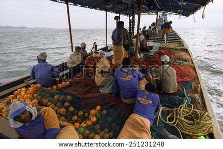 KANNUR, INDIA - DECEMBER 22, 2011: Fishermen set out to sea in traditional wooden boat heading for deep waters in the Arabian Sea on December 22, 2011 near Kannur, Kerala, south India.