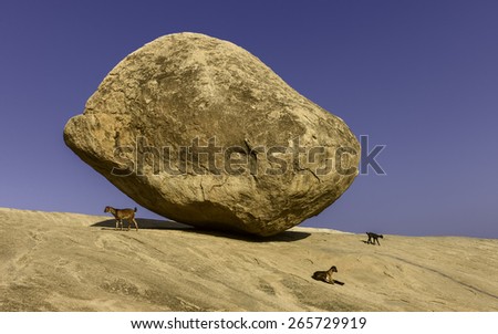 Mamallapuram, Tamil Nadu, India. A large boulder, Krishna\'s butter ball, named after Hindu God, Krishna, balanced precariously on granite base at Mamallapuram, Tamil Nadu, India.