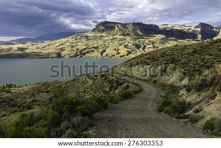 Cody, Wyoming, USA. The arid landscape of Buffalo Bill State Park with the Shoshone River flanked by rolling landscape and mountains  at dawn on a summer day near Cody, Wyoming, USA.