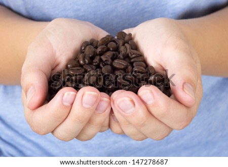 Coffee beans in woman palms closeup