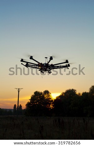 Drone on a background of a beautiful sunset. UAV in flight. Quadrocopters on radio.