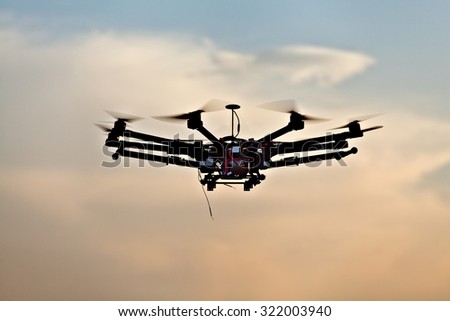 Drone on a background of a beautiful sunset. UAV in flight. Quadrocopters on radio.