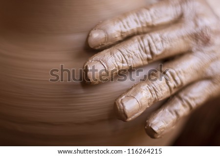 hands of potter do a clay pot