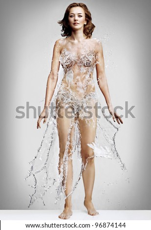 Beautiful woman in a dress made of water splashes