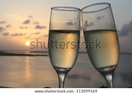 Flutes of champagne with sunset background
