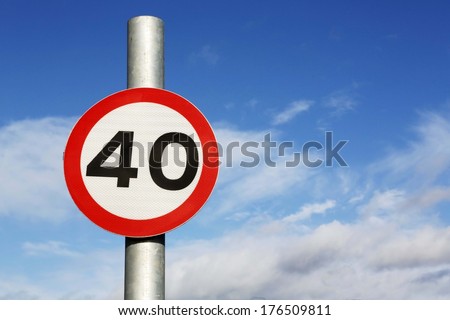 Forty miles per hour speed limit sign against a partly cloudy sky.