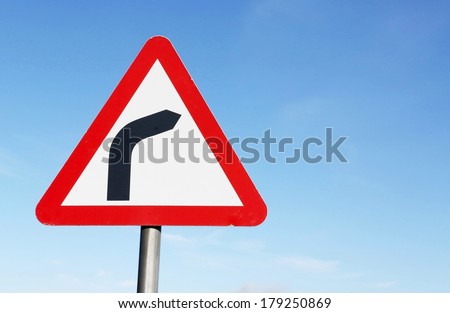 Road sign warning of a sharp bend ahead.