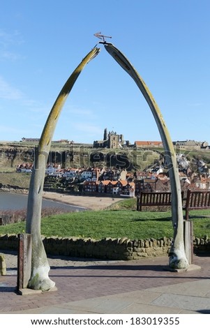 Whitby whale bones framing the Church of Saint Mary and Whitby Abbey against a clear blue sky.