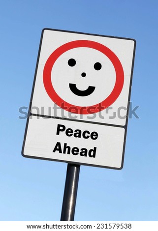 Peace Ahead written on a road sign with a smiling face against a clear blue sky background