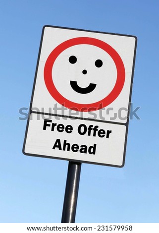 Free Offer Ahead written on a road sign with a smiling face against a clear blue sky background