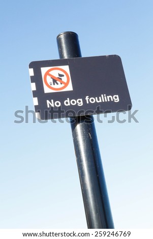No dog fouling sign against a clear blue sky background