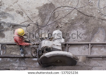 worker was incisesing the stone, He move the cutting machine along the guide rail reciprocating time and time again.
