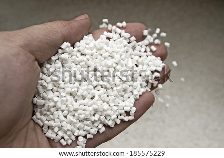 Plastic pellets in holding hand, raw material of injection molding.