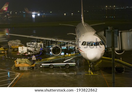 Guangzhou, China - April 29, 2014:  Sichuan Airlines  passenger flight being loaded up with cargo at Guangzhou Baiyun International Airport at night.