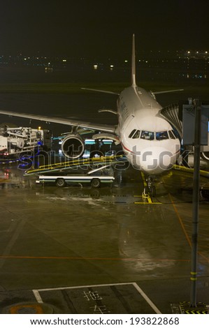 Guangzhou, China - April 29, 2014:  Sichuan Airlines  passenger flight being loaded up with cargo at Guangzhou Baiyun International Airport at night.