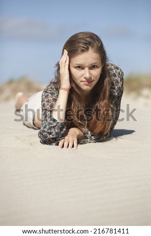 Young beautiful woman lying on the sand and enjoy your vacation