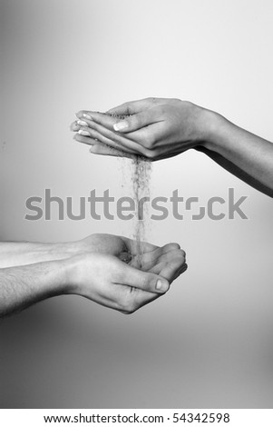 female hand give in to male hahds sand