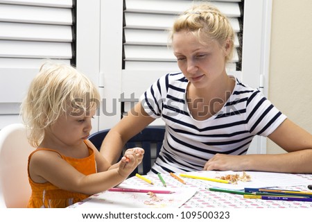 mother teaching to draw her daughter