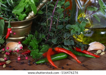 Mixed herbs of sage, rosemary, basil with red hot pepper in mortar with pestle