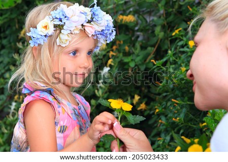 girl with a wreath of flowers look at mom