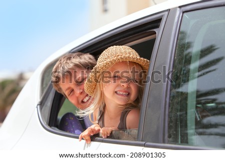 Off to the beach!   Portrait of two happy children inside the car .