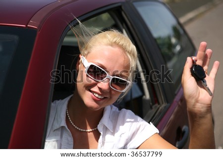young blonde woman with keys in the car