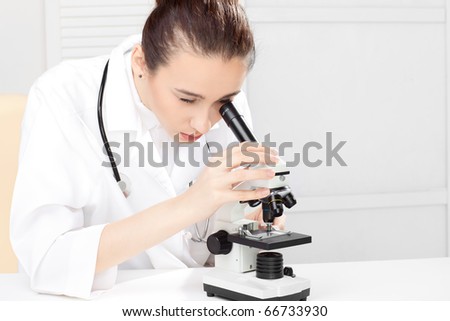 Female medical doctor working with a microscope