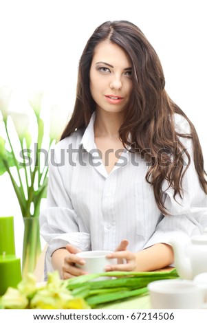 Woman dirinking tea smiling and looking at camera wearing formal clothes