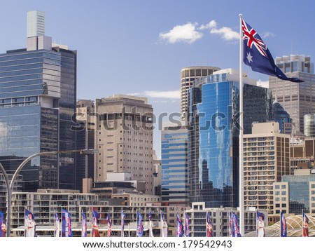 Skyline image showing several Sydney buildings in the Darling Harbour area with a large Australian flag in the foreground.