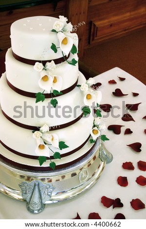stock photo Beautiful wedding cake with flower details and petals on table