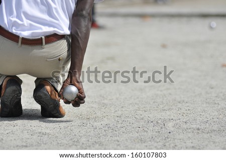 holding a petanque ball to make a throw