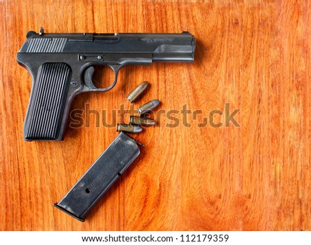 Gun and bullets on wood  table