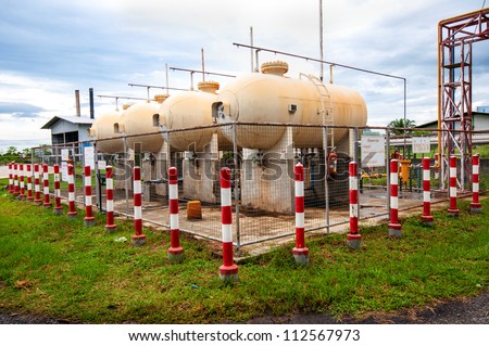 Liquid Petroleum Gas (LPG) storage unit inside a fence to prevent dangerous unauthorized intervention. Concept of Oil and Gas safety pre-caution measure.