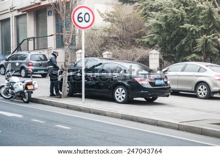 Dalian, China January 18, 2015: Dalian police officer writing parking ticket.