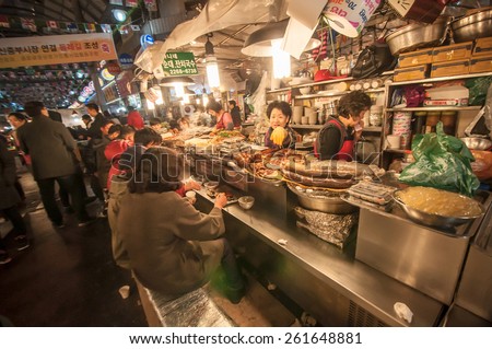 SEOUL, SOUTH KOREA - FEBRUARY 28, 2015 : People enjoying street food at Gwangjang Market.The market was established in 1905 .It has many restaurants and food stalls selling traditional Korean cuisine.