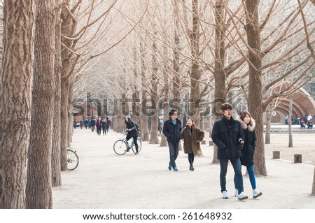 CHUNCHEON, SOUTH KOREA - FEBRUARY 28, 2015: Tourists enjoy one of the many tree-lined trails of Nami Island (Namiseom), where the popular Korean drama Winter Sonata was filmed.