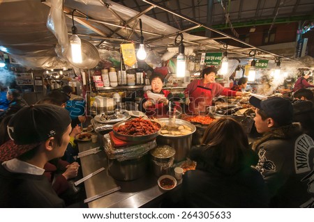 SEOUL, SOUTH KOREA - FEBRUARY 28, 2015 : People enjoying street food at Gwangjang Market.The market was established in 1905 .It has many restaurants and food stalls selling traditional Korean cuisine.